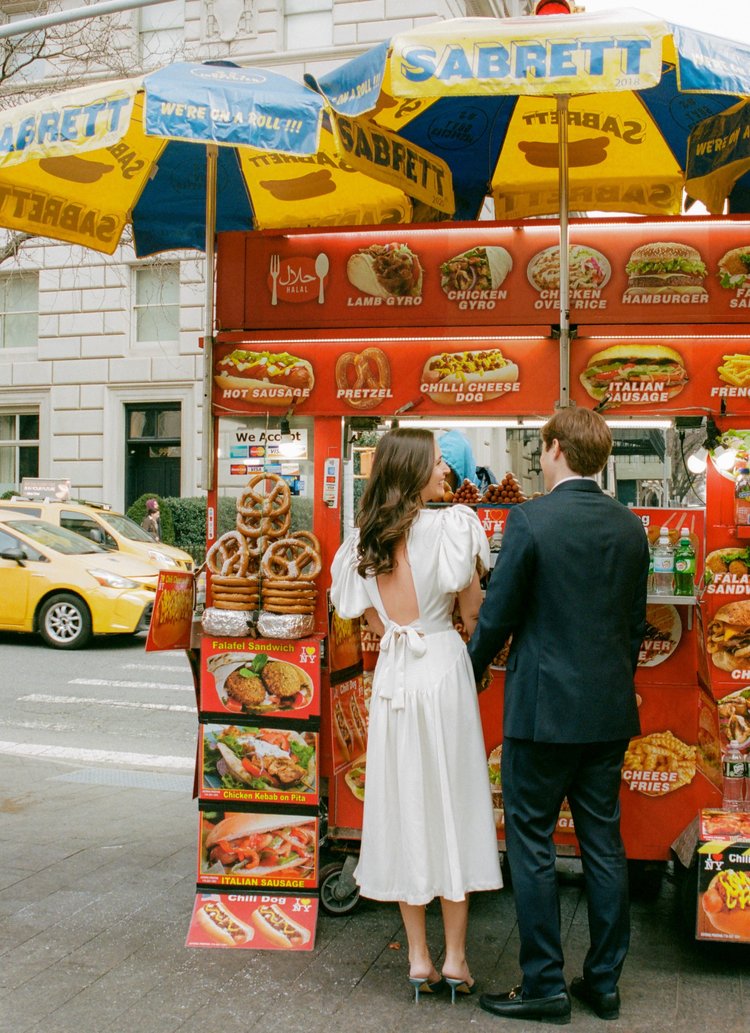 couple at hot dog stand nyc engagement photo outside metropolitan museum of art (MET) shot on film by parkers pictures