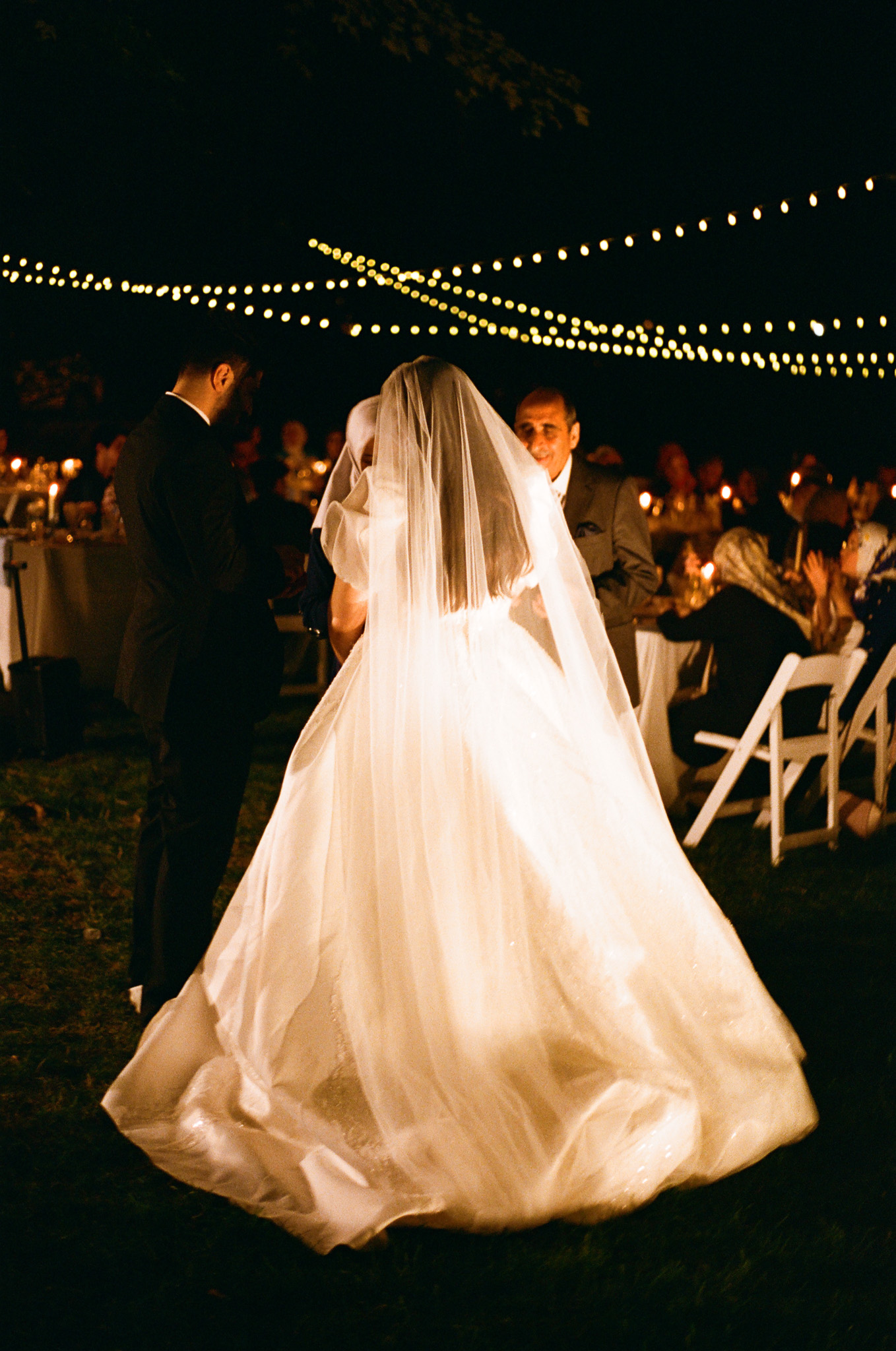 couple underneath twinkle lights at outdoor wedding shot on film by parkers pictures