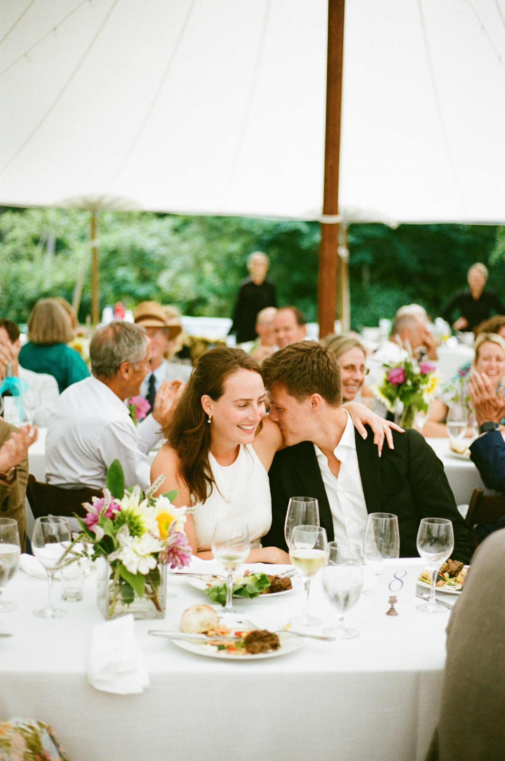 couple at duxbury Massachusetts wedding kissing during speeches under the tent shot on 35mm film by parkers pictures