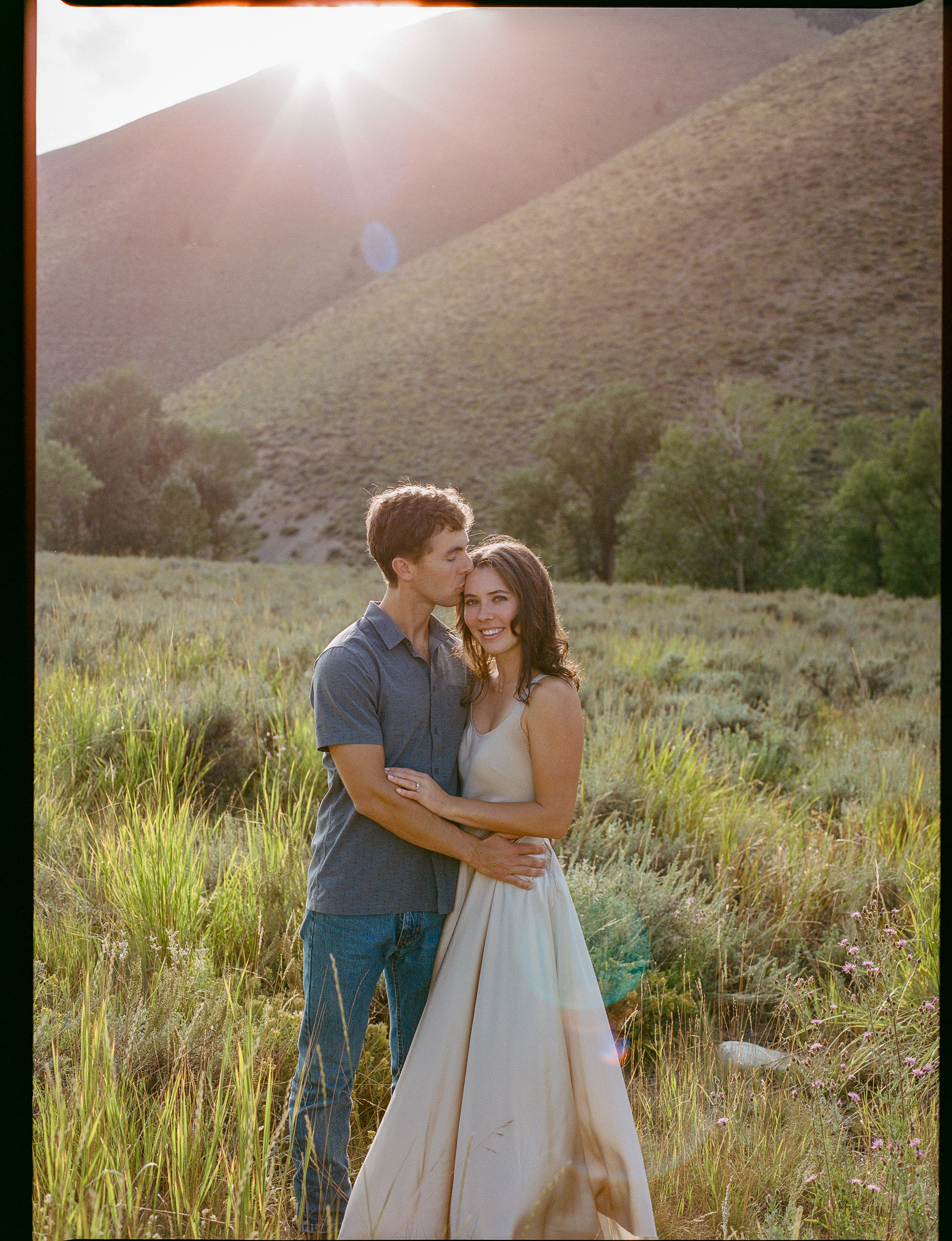 couple in field at sunset engagement photo in Sun Valley Idaho shot on film by parkers pictures