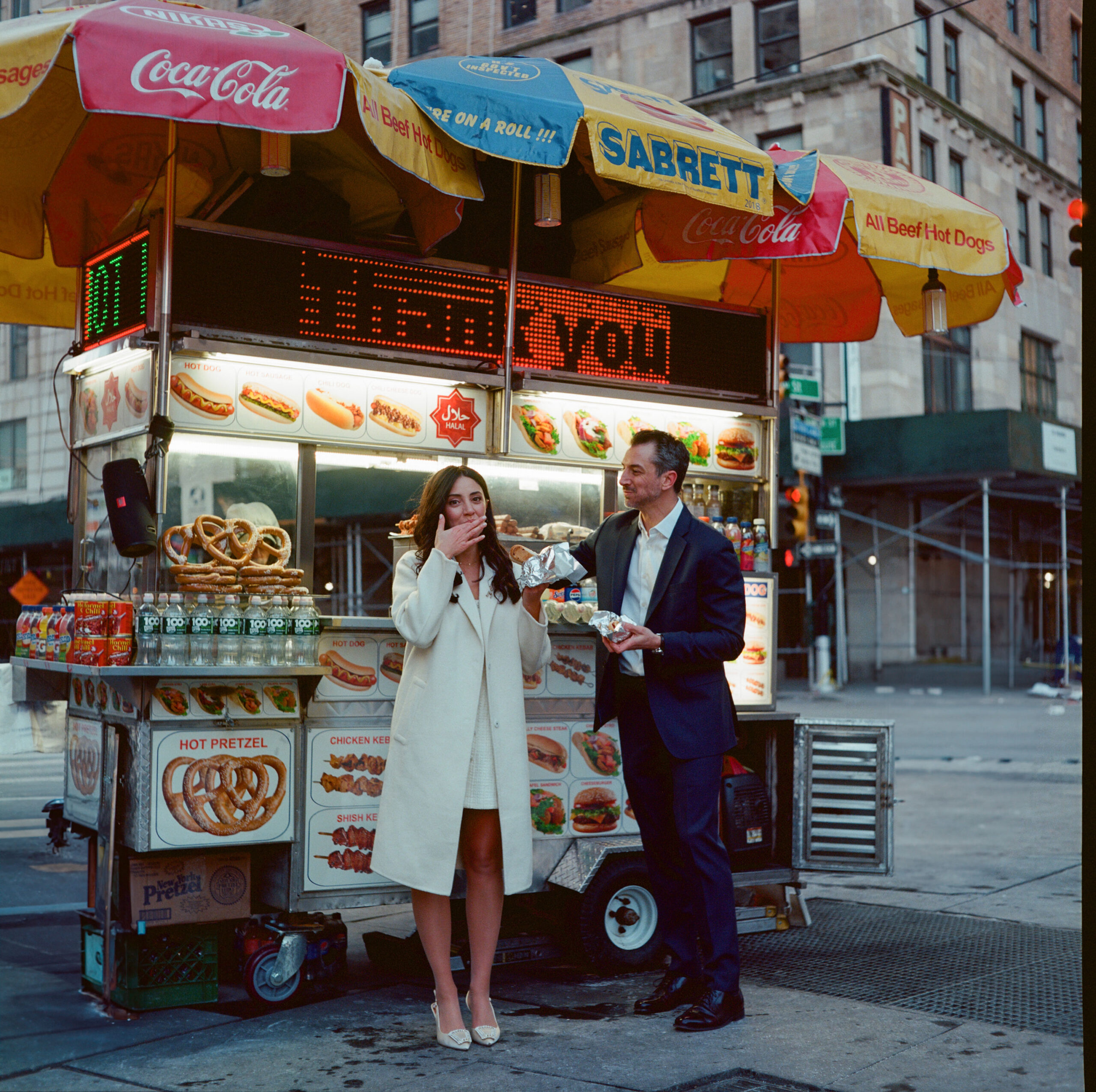 couple at hot dog stand nyc engagement photo outside metropolitan museum of art (MET) shot on film by parkers pictures