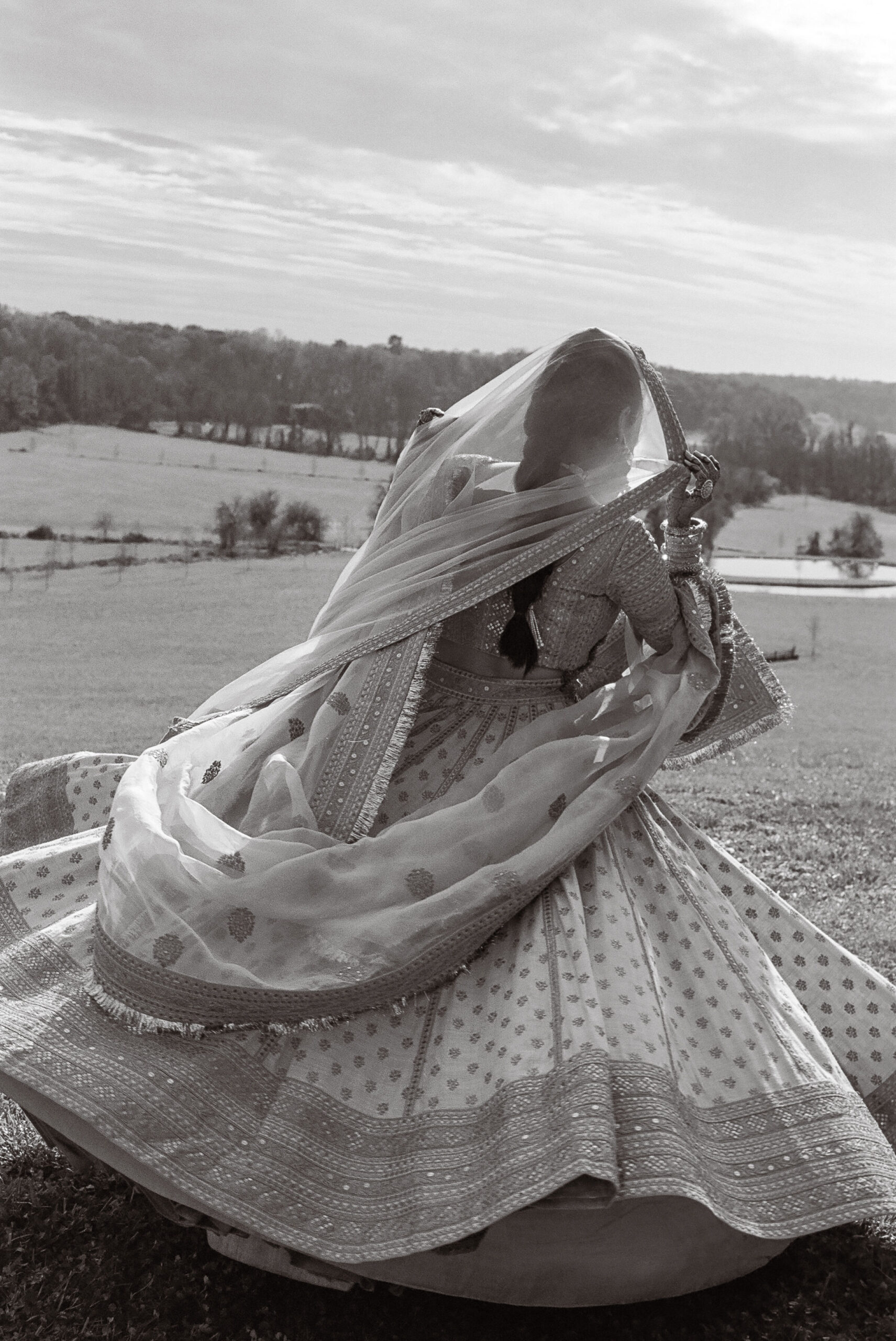 bride spinning in a field sikh wedding in maryland shot on film by parkers pictures