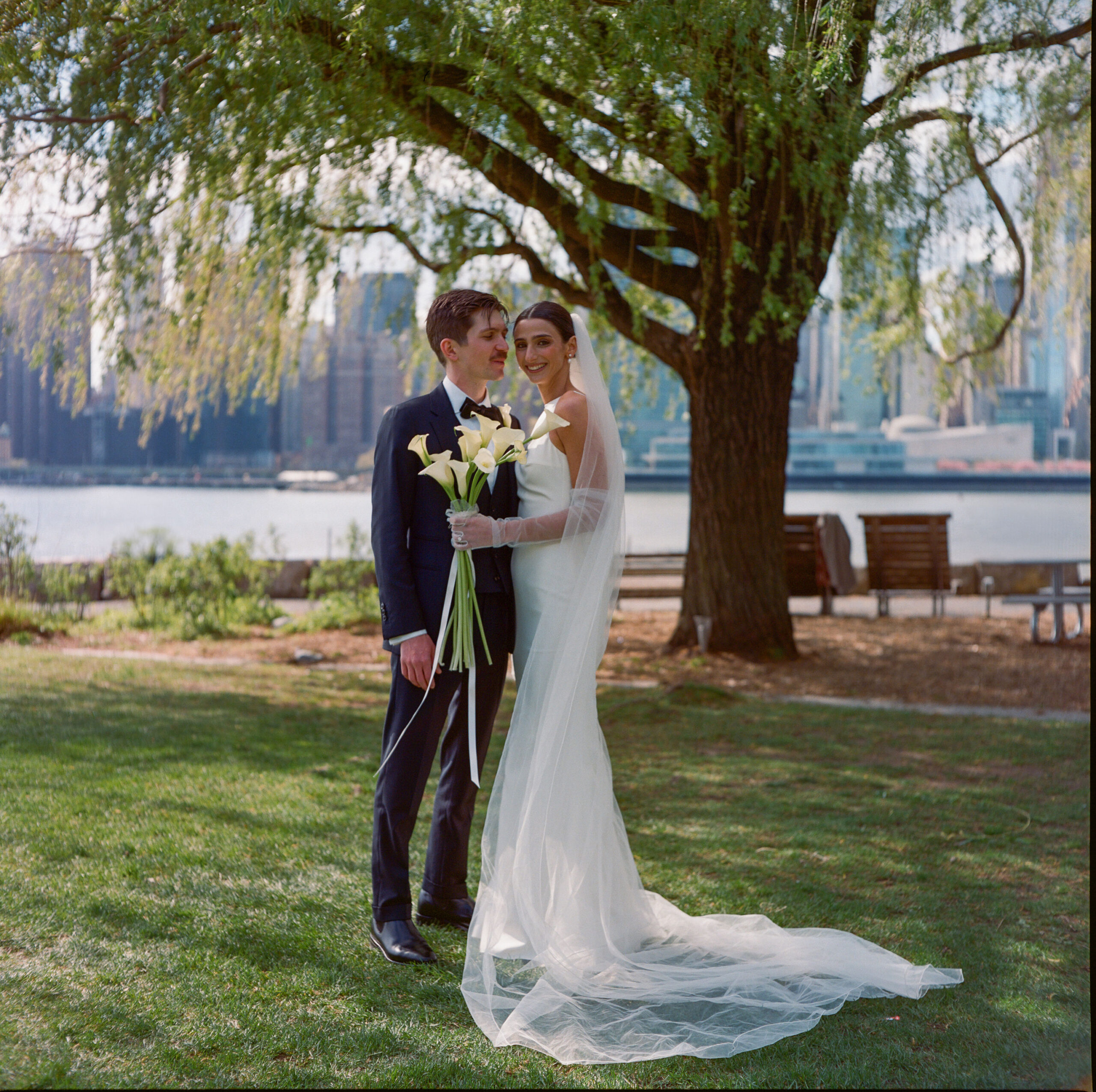 groom and bride with callalilies against the New York City skyline wedding shot on medium format film