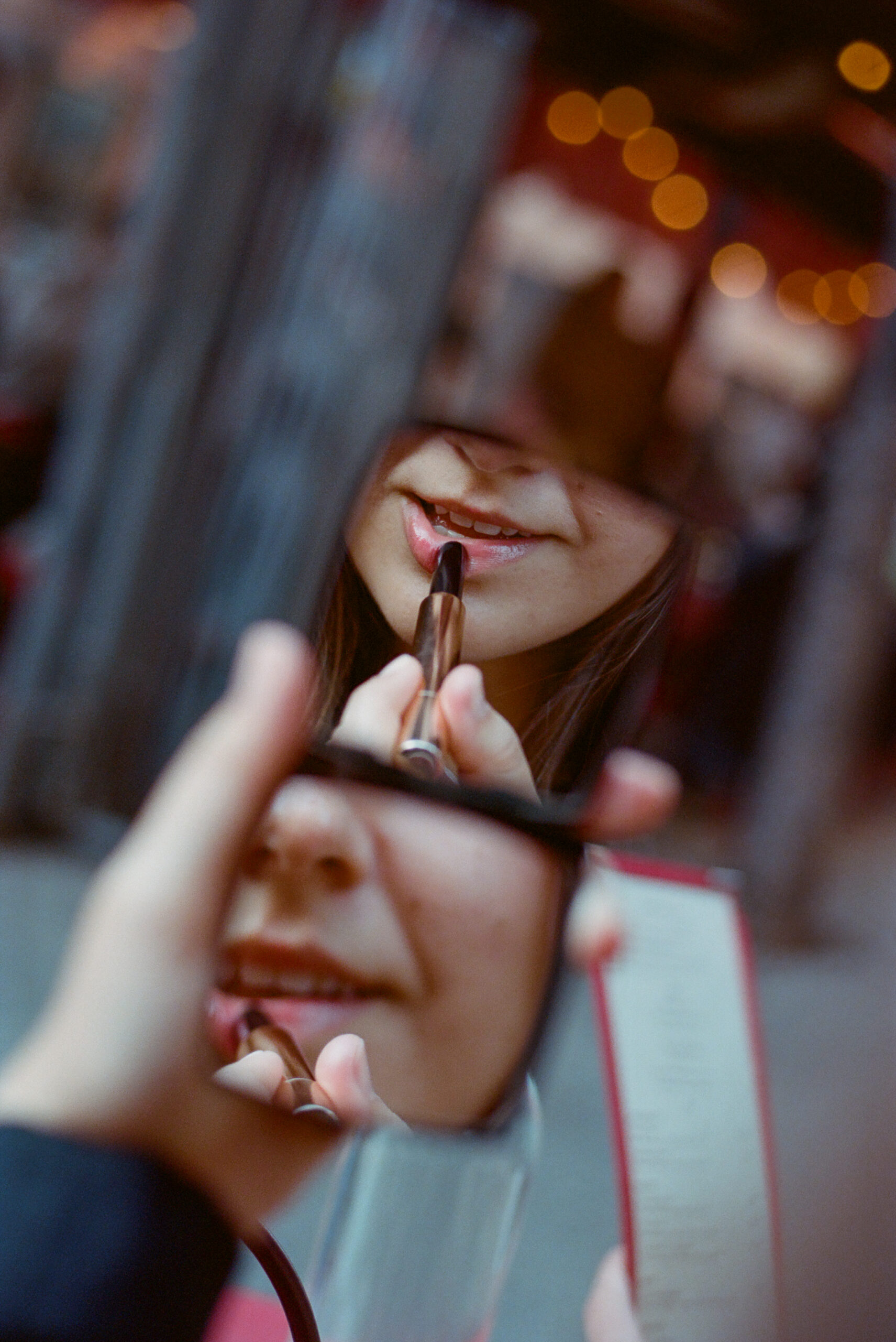 engagement shoot at le dive nyc bride adjusting lipstick in mirror shot on film by parkers pictures