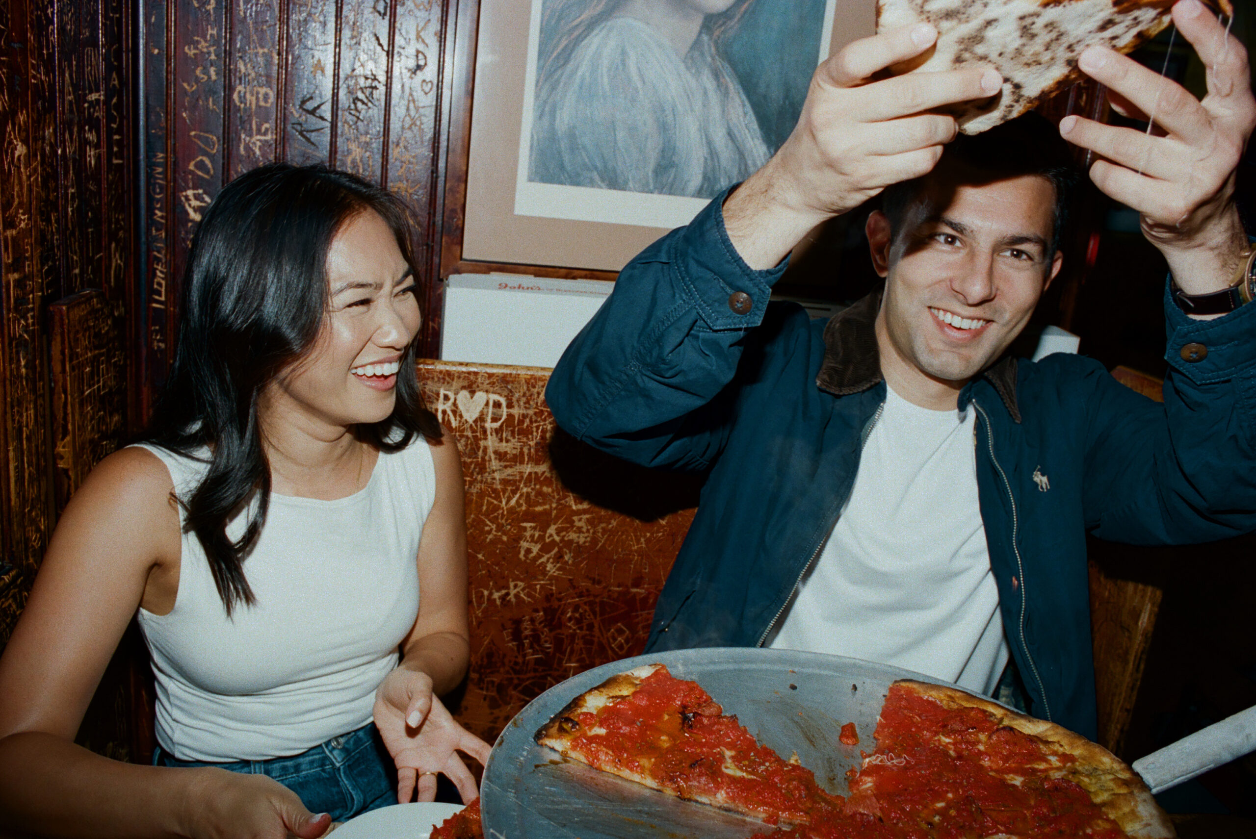 couple eating pizza engagement photo at johns on bleeker street shot on film by parkers pictures