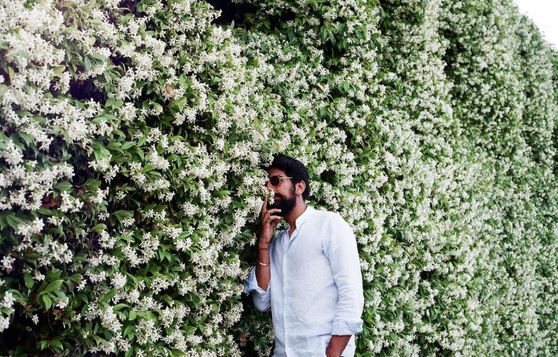 man against flower wall in Lake Garda Italy shot on film by Parkers Pictures