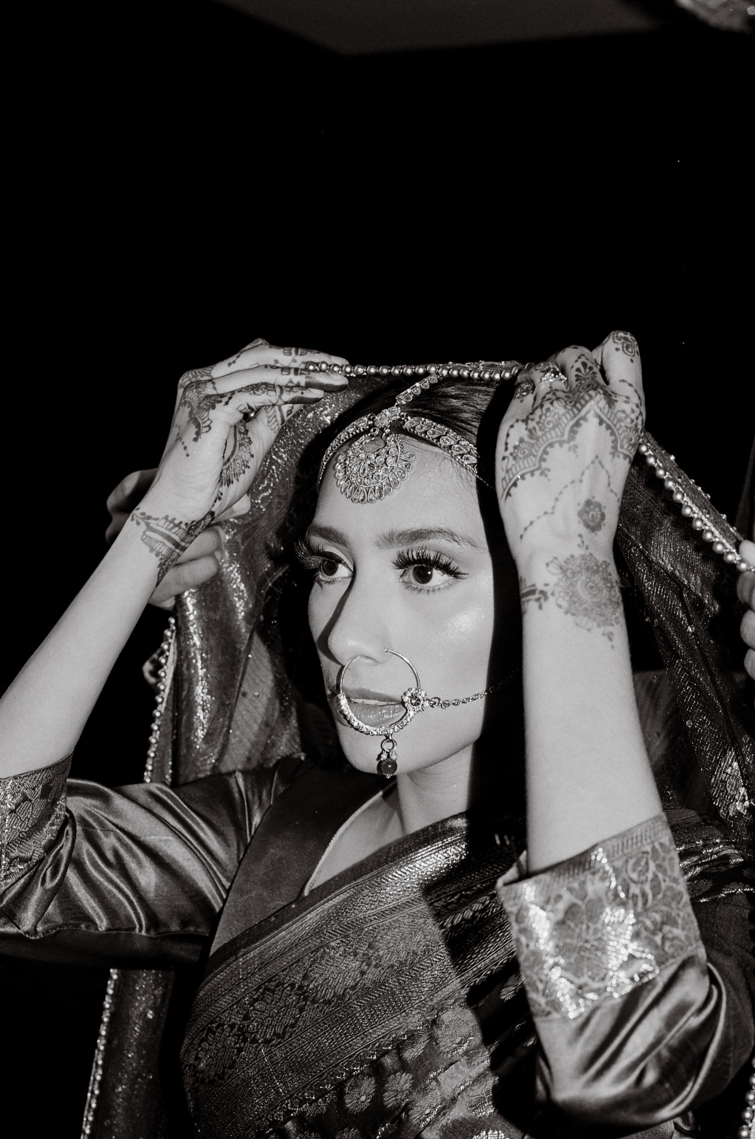 Bangladeshi bride putting on sari for wedding shot on 35mm black and white film by parkers pictures